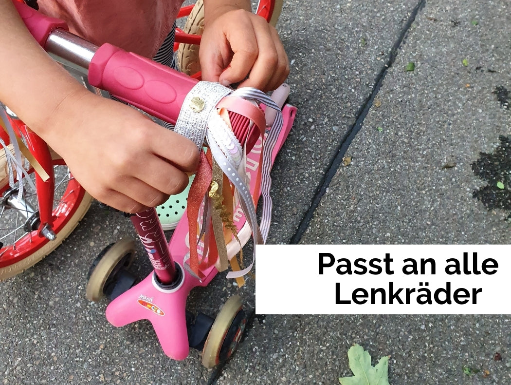 Ein Kind befestigt eine Fahrradtassel am Trottinett.