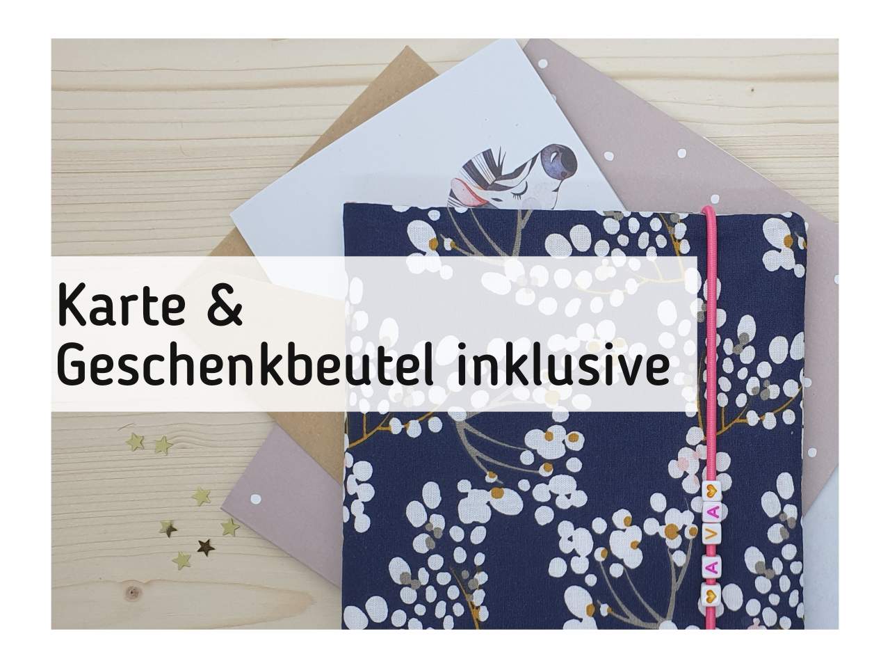 Eine Pixibuchhülle, Geschenkbeutel und Karte liegen auf einem Tisch.