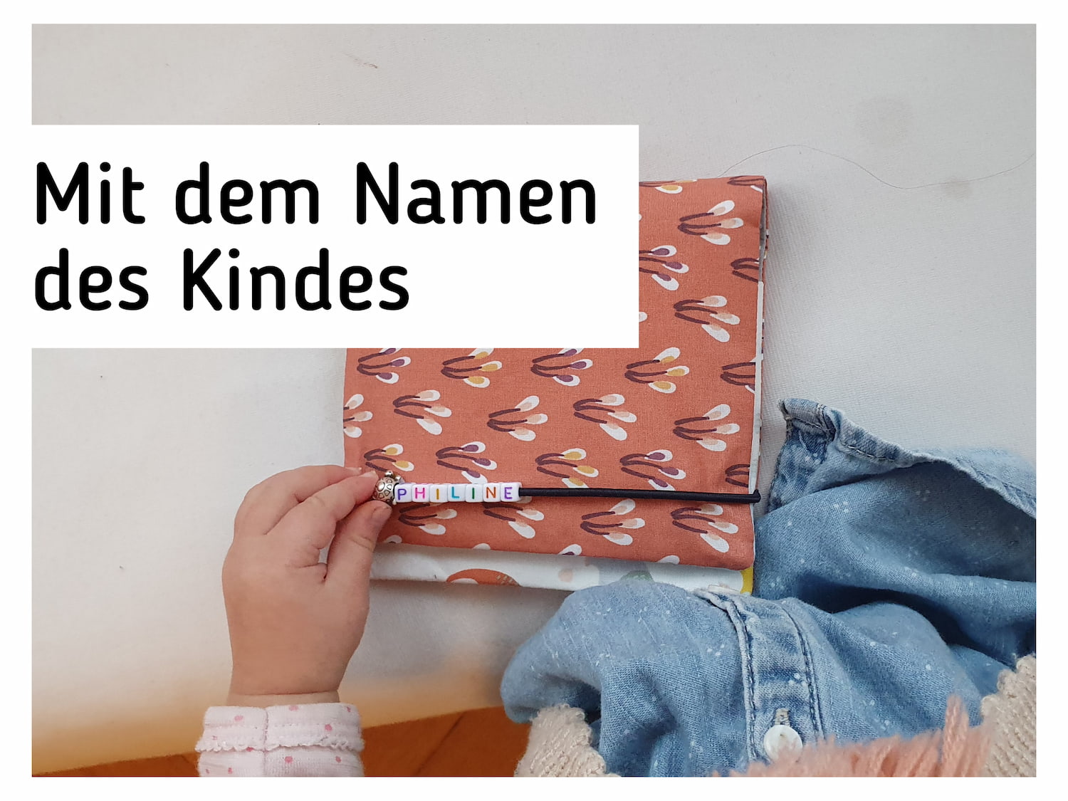 Ein Kind spielt mit Perlen an einer Pixibuchhuelle.